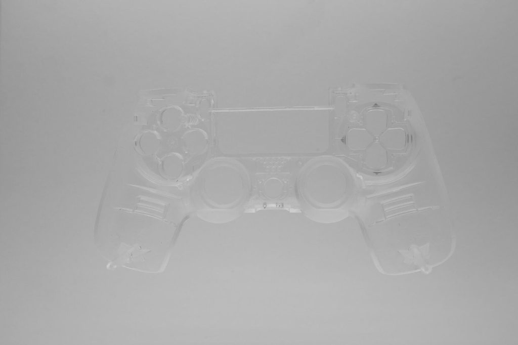 Ein durchsichtiges PS4 Front Case transparentes Gehäuse JDM040 ist vor einem schlichten, hellgrauen Hintergrund zentriert und erinnert an den ikonischen PlayStation-Stil.